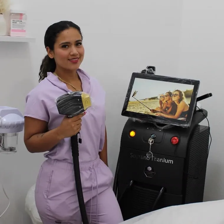 Yurany Vargas standing beside her Soprano Titanium laser machine in the studio